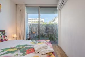 - une chambre avec un lit et une grande fenêtre dans l'établissement Apartamento Qian Caves de Gaia, à Vila Nova de Gaia