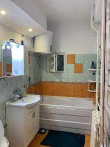 ein Badezimmer mit einer weißen Badewanne und einem Waschbecken in der Unterkunft Vali Apart in Mangalia