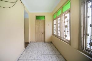 an empty hallway with a door and windows at SPOT ON Harini Lodge in Chennai