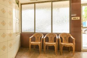 three chairs sitting in front of a window at SPOT ON Harini Lodge in Chennai