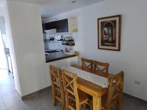 eine Küche und ein Esszimmer mit einem Holztisch und Stühlen in der Unterkunft Duplex Escritores Argentinos in Rawson