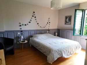 sypialnia z łóżkiem i żyrandolem w obiekcie Maison cosy à Saint-Méloir-des-Ondes avec jardin privé w mieście Saint-Méloir-des-Ondes