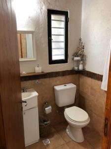 a bathroom with a toilet and a sink and a mirror at Stunning modern apartment in gated community in Ciudad Lujan de Cuyo