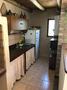 La cuisine est équipée d'un évier et d'un réfrigérateur. dans l'établissement Stunning modern apartment in gated community, à Luján de Cuyo