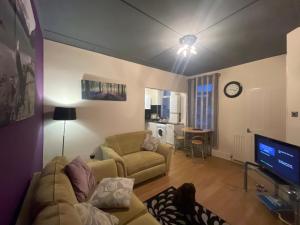 a living room with a couch and a tv at The Beach Loft in Newbiggin-by-the-Sea