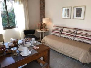 Un dormitorio con una cama y una mesa con tazas y platos. en Stunning modern apartment in gated community en Luján de Cuyo