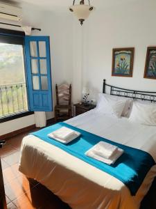 a bedroom with a bed with two towels on it at Villa en Frigiliana con Piscina y Jacuzzi in Frigiliana