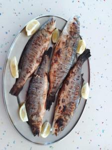 4 peces en un plato con rodajas de limón en La Mimosa, en Porto Garibaldi