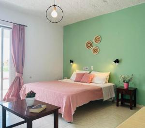 a bedroom with a large bed with a pink blanket at Rodakino Βay in Rodakino