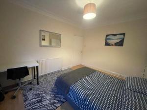 a bedroom with a bed and a desk in it at The Beach Loft in Newbiggin-by-the-Sea