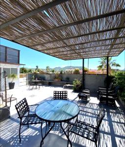 un patio con mesa y sillas bajo un techo de madera en Villa Esterito, en La Paz