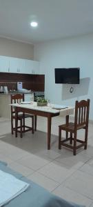 cocina con mesa y 2 sillas y TV en Monoambiente Centrico, en Santiago del Estero