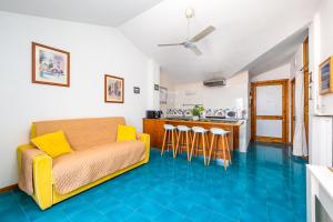 ein Wohnzimmer mit einem Sofa und einer Küche in der Unterkunft La Mansardina dell'Agrumeto in Vico Equense