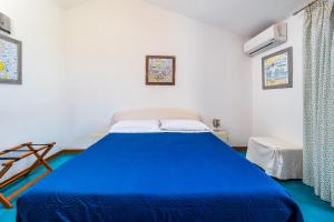 ein Schlafzimmer mit einem blauen Bett in einem Zimmer in der Unterkunft La Mansardina dell'Agrumeto in Vico Equense