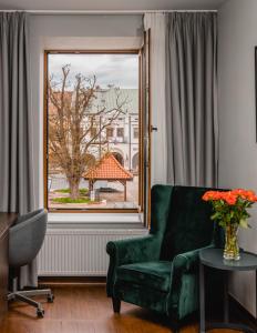 a living room with a green couch and a window at The Old Townhouse II in Krosno