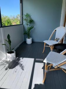- un balcon avec 2 chaises, une table et des plantes dans l'établissement Executive 2 Bedroom House, à Lismore