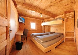 a bedroom with a bunk bed in a wooden cabin at Ferienhof Holzmeister in Sankt Jakob in Haus