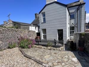a house with a stone walkway in front of it at Tregwylan in Nefyn