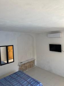 um quarto com uma cama e uma televisão na parede em Casa nova 7 PRIVATE BATHROOM AND ROOM 2 BEDS em Cancún