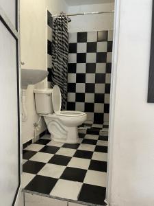 uma casa de banho com um WC e um piso xadrez preto e branco em Casa nova 7 PRIVATE BATHROOM AND ROOM 2 BEDS em Cancún