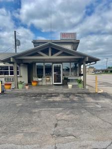 a building with a motel sign on top of it at Economy Inn in Ada