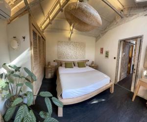 ein Schlafzimmer mit einem großen Bett und einer Pflanze in der Unterkunft VILLA 3 BEDROOMS BEAULIEU SUR MER in Beaulieu-sur-Mer + 42 Fotos