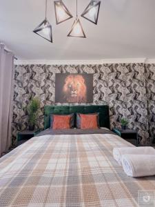 a bedroom with a large bed with a lion painting on the wall at RentHouse Apartments Urban Lion in Chişinău