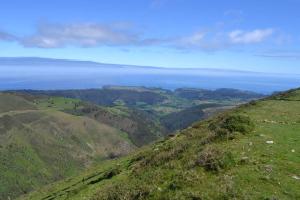 a view from the top of a hill with the ocean in the background at Hotel Restaurante el Fornon in Novellana