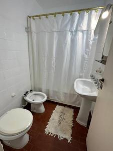 La salle de bains blanche est pourvue de toilettes et d'un lavabo. dans l'établissement Excelente ubicación en el corazón de San Fdo., à San Fernando