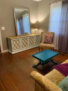 a living room with a table and a mirror at The Jungalow in Brookhaven