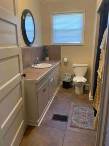 uma casa de banho com um lavatório, um WC e um espelho. em The Jungalow em Brookhaven
