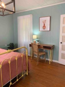 a bedroom with a desk and a bed and a table and chair at The Jungalow in Brookhaven