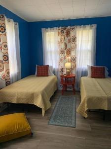 um quarto azul com duas camas e uma mesa em The Jungalow em Brookhaven