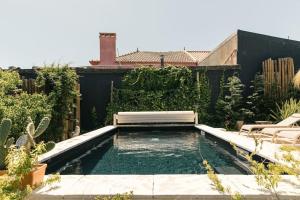 Casa da Aldeia - Small House -Terra - Peniche - Baleal في Casais Brancos: حمام سباحة مع مقعد في الفناء الخلفي