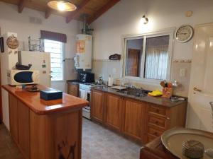 cocina con armarios de madera y nevera blanca en La Casita - Chalet de Montaña en Villa General Belgrano