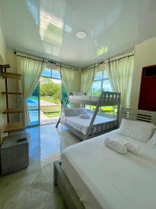 1 dormitorio con 2 camas y ventana grande en Finca Turística La Sofileña, en Guamal