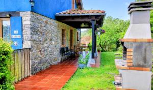 a stone house with an awning and a patio at La Casina de Labra in Cangas de Onís