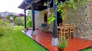 a stone house with a table and chairs on a patio at La Casina de Labra in Cangas de Onís +42 photos