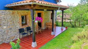 a pavilion with a table and chairs on a patio at La Casina de Labra in Cangas de Onís
