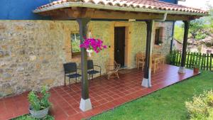 a pergola on a patio with a table and chairs at La Casina de Labra in Cangas de Onís