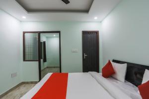 1 dormitorio con 1 cama con manta roja en OYO 63814 The New View Hotel, en Greater Noida