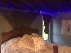 - une chambre dotée d'un lit avec des lumières violettes dans l'établissement Treehouse Magpies Nest with bubble pool, à Avesta