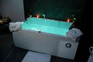 a white bath tub with candles in a bathroom at Wellness Home Catania in Catania