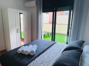 a bedroom with a bed with two rolled towels on it at Beach Apartment Artigas in Badalona