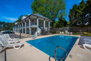 a swimming pool with chairs and a house at Red Roof Inn Jasper in Jasper