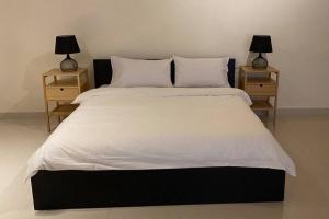 een slaapkamer met een groot bed met 2 nachtkastjes bij استوديو في المدينة المنورة in Al Madinah