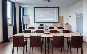 einen Konferenzraum mit einem großen Tisch und Stühlen in der Unterkunft Coffee Fellows Hotel München-Freiham in München
