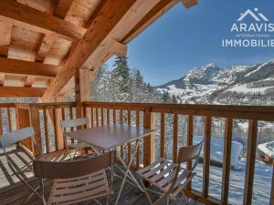 a table and chairs on a deck with mountains at Appartement Le Grand-Bornand, 5 pièces, 8 personnes - FR-1-391-96 in Le Grand-Bornand