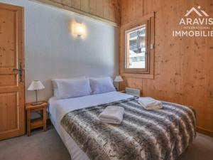 a bedroom with a bed with two towels on it at Appartement Le Grand-Bornand, 5 pièces, 8 personnes - FR-1-391-96 in Le Grand-Bornand