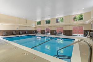 a swimming pool in a large building with tables and chairs at Fairfield Inn & Suites by Marriott Hickory in Hickory